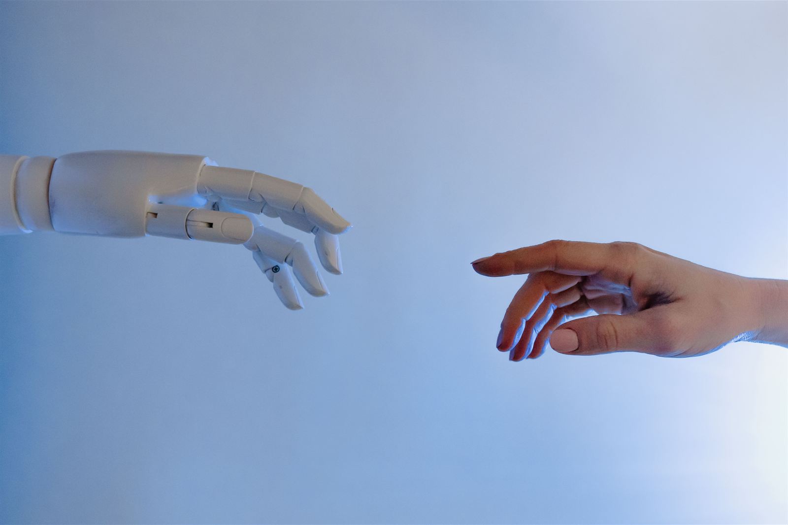 A human hand and a robotic hand reaching toward each other, symbolising the collaboration between AI and humans in music