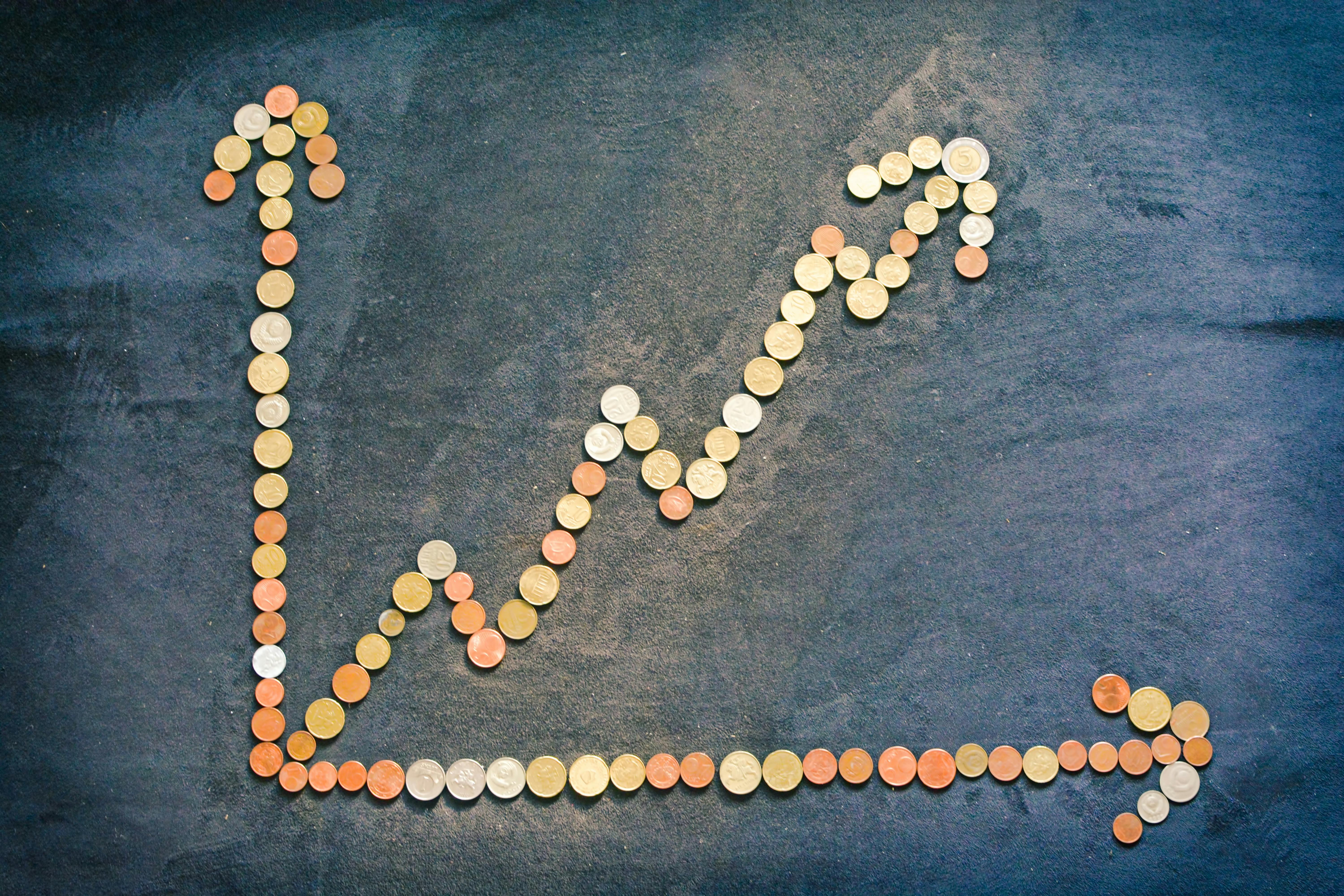 Stack of coins next to scattered cash, symbolising music royalty earnings